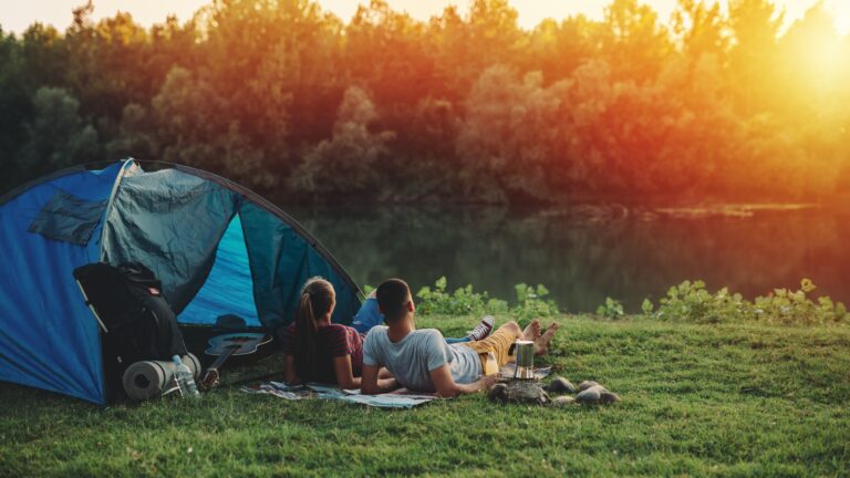 young couple relaxing by the river. camping outdoor